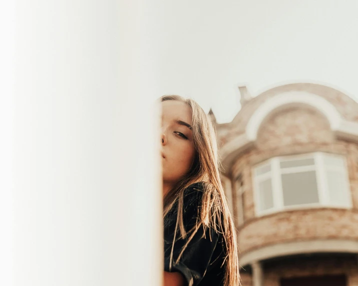 a woman is looking out from behind a window