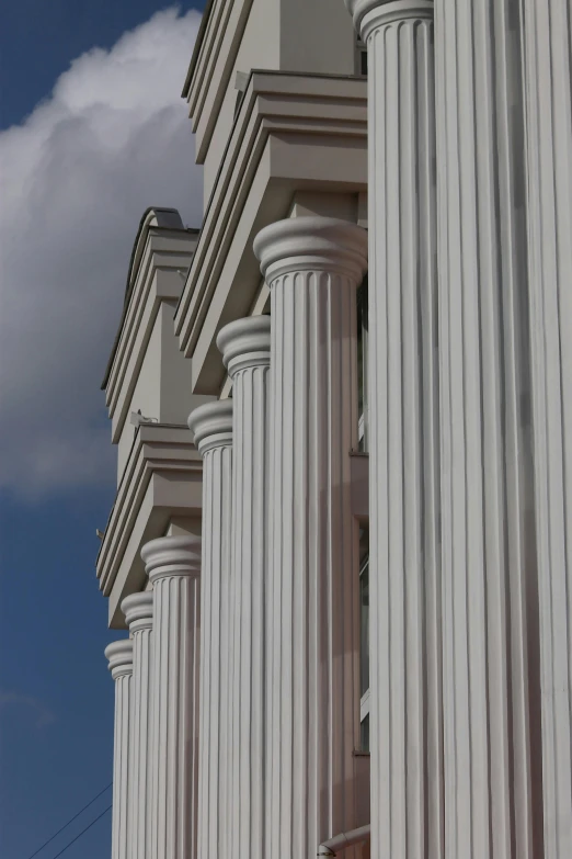 large columns of white marble against a blue cloudy sky