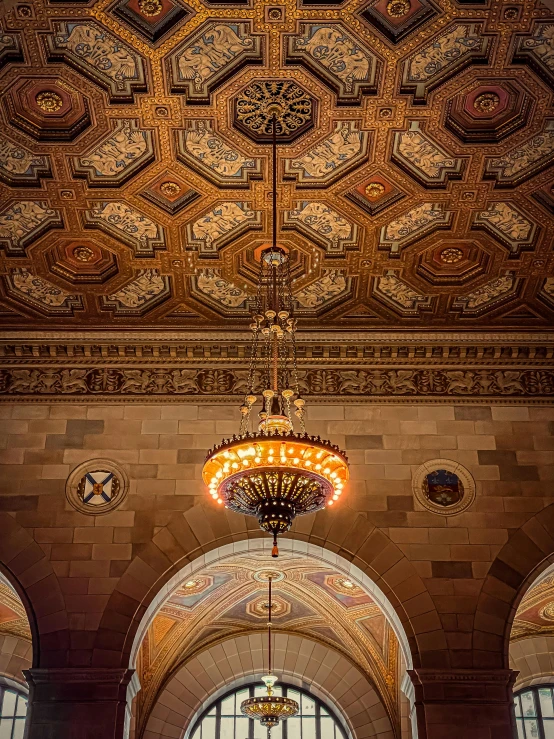 a large chandelier hangs in the middle of a hall