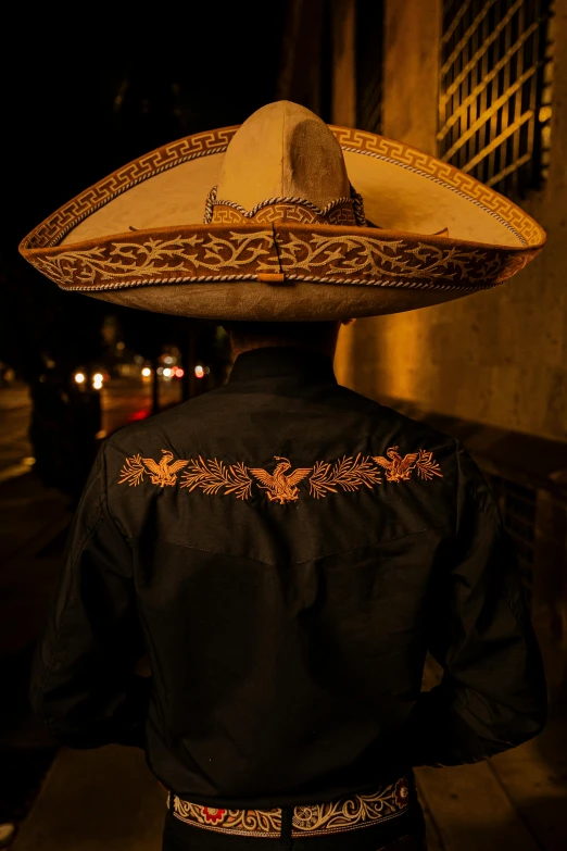 a man with a sombrero stands by a street
