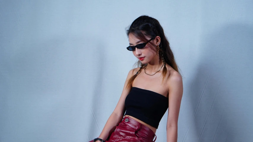 a woman is posing for the camera with her red leather purse