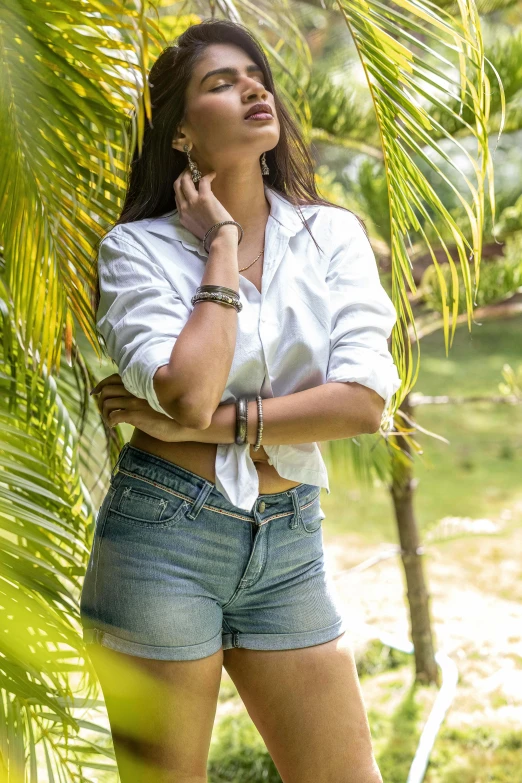 a women is standing near a leafy tree