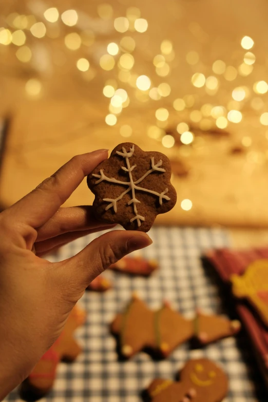 there is a hand holding a cookie decorated with a cross