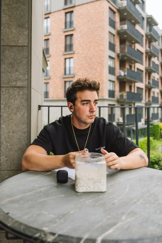 a man is sitting outside eating in a table