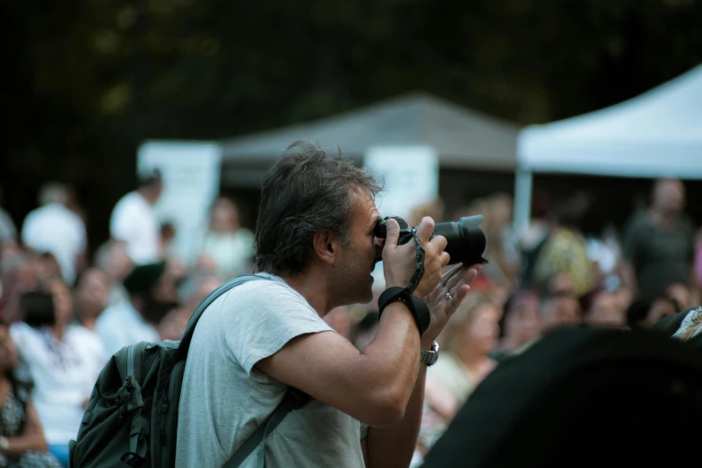 a pographer takes a picture at an outdoor gathering