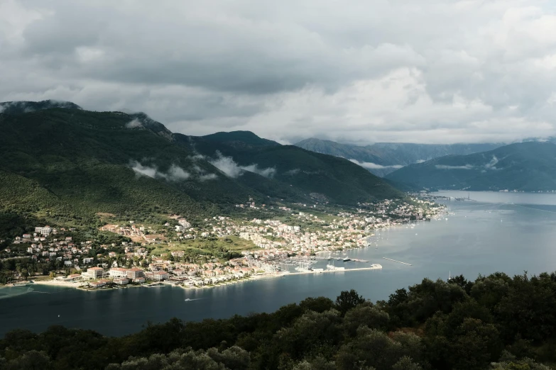 the village sits on a hill with the mountain and lake in the distance