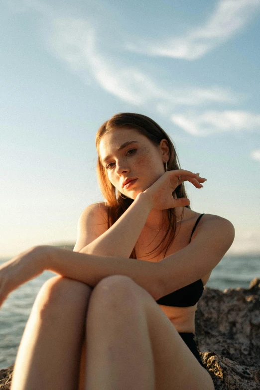 a girl sitting on rocks with her feet propped out on the rock