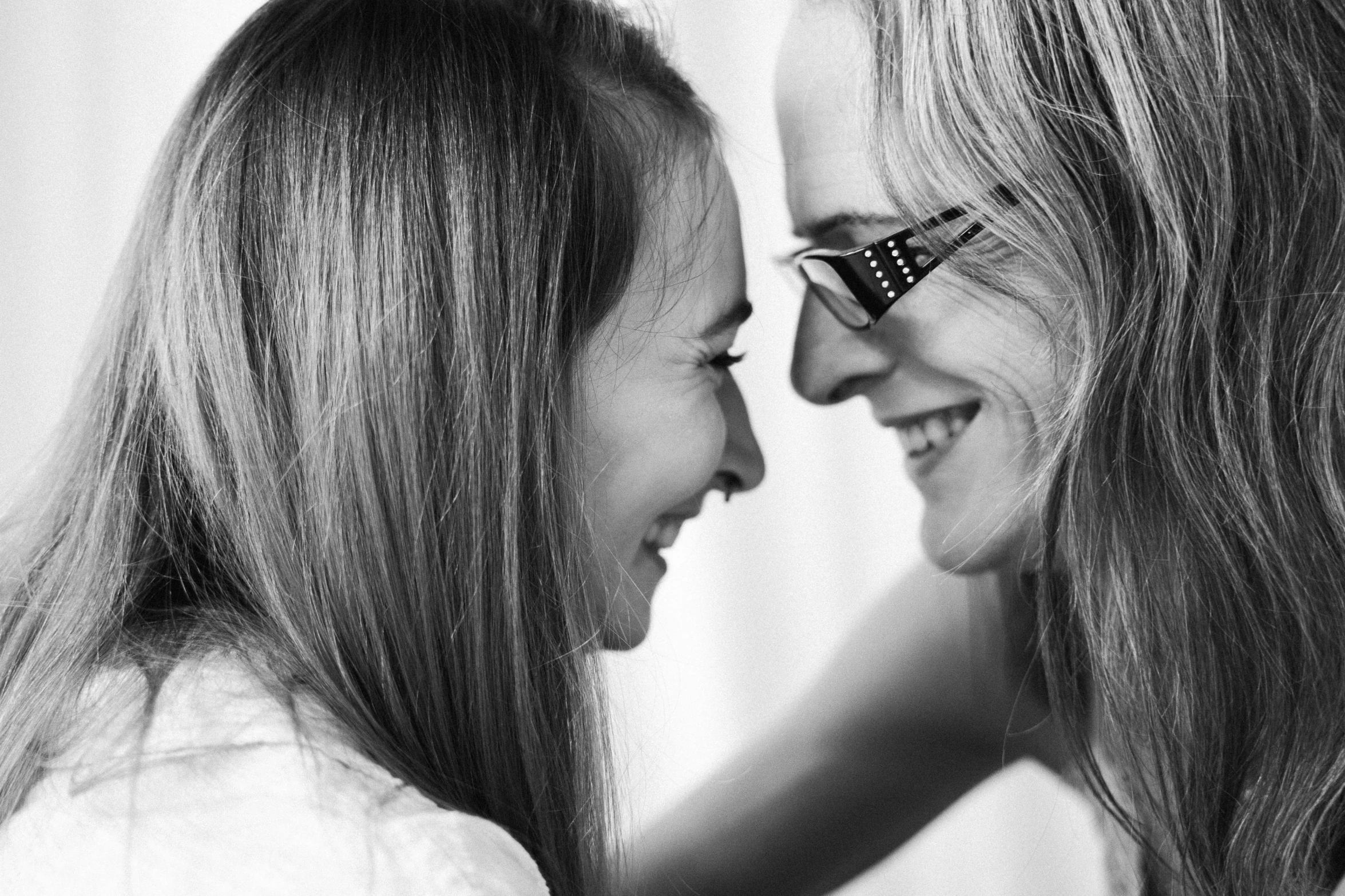 two girls looking at each other laughing and laughing