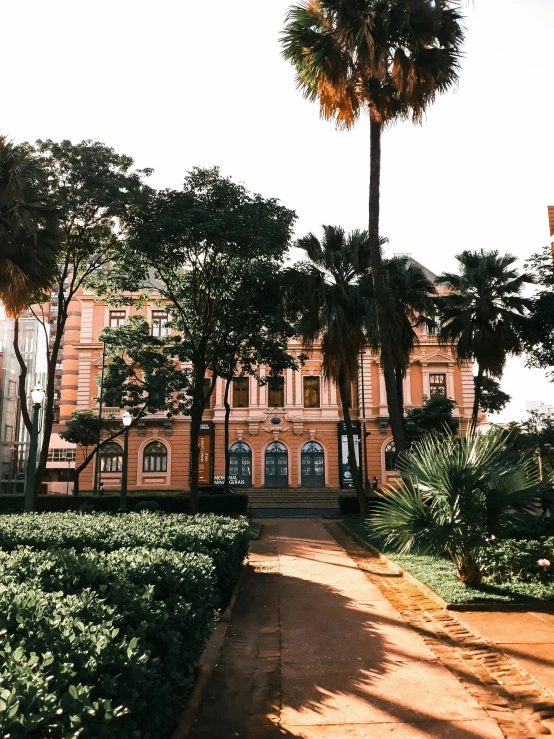 a large brown building surrounded by trees and bushes