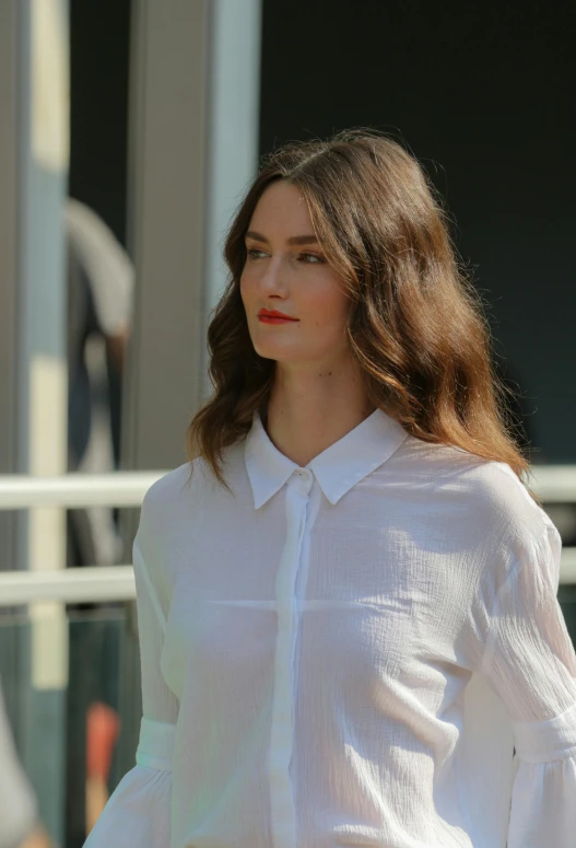 a woman with long hair wearing a white shirt