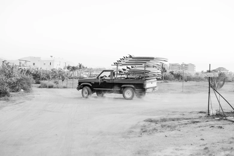 a truck with skis is going down a dirt road