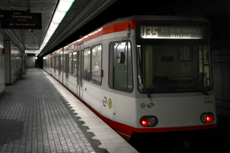 an empty subway train in the station is red and white