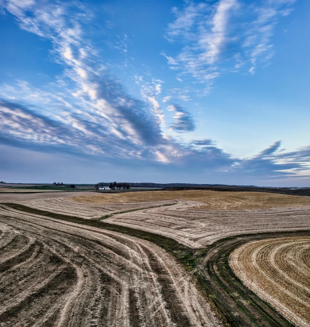 an empty farm area under a cloudy blue sky