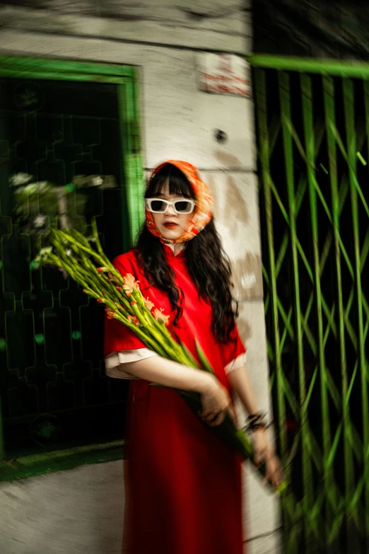 a woman in red is standing near a gate