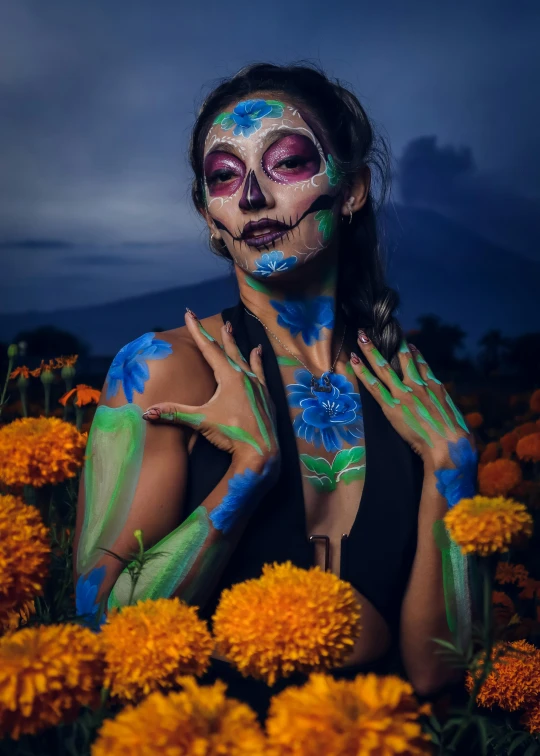 a woman in a body painting is surrounded by yellow flowers