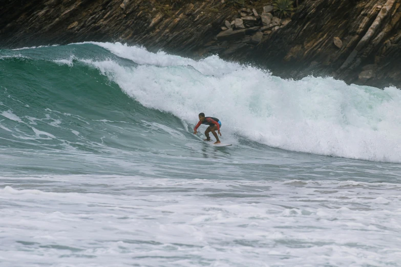 a man riding a surfboard on top of a wave