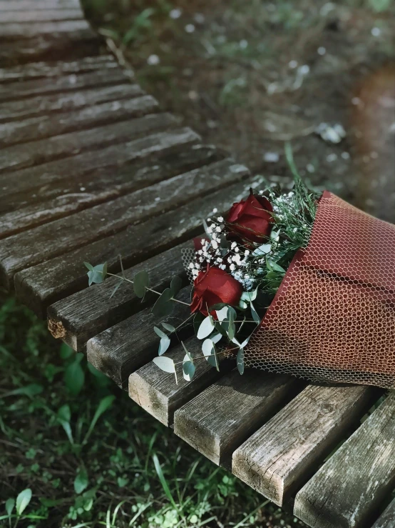 a bouquet of roses lying on a bench