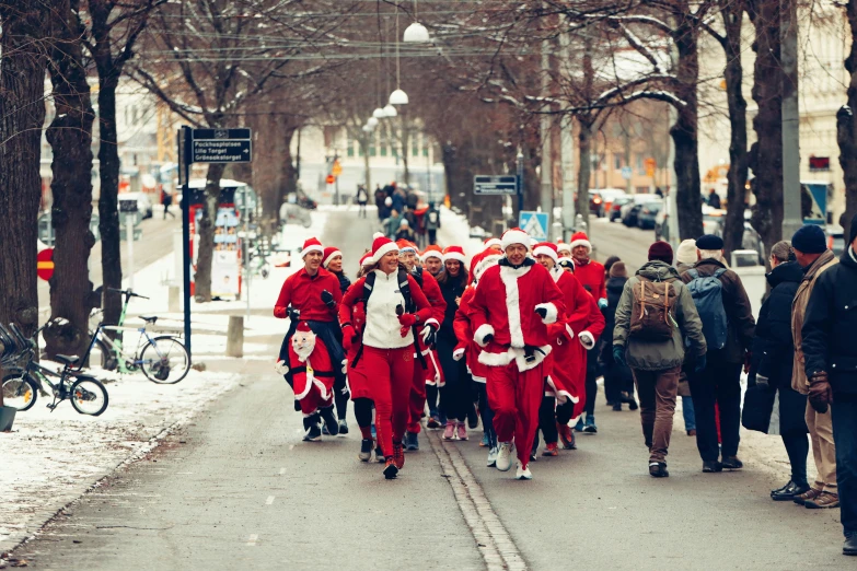 many people in santa claus outfits are walking down the street