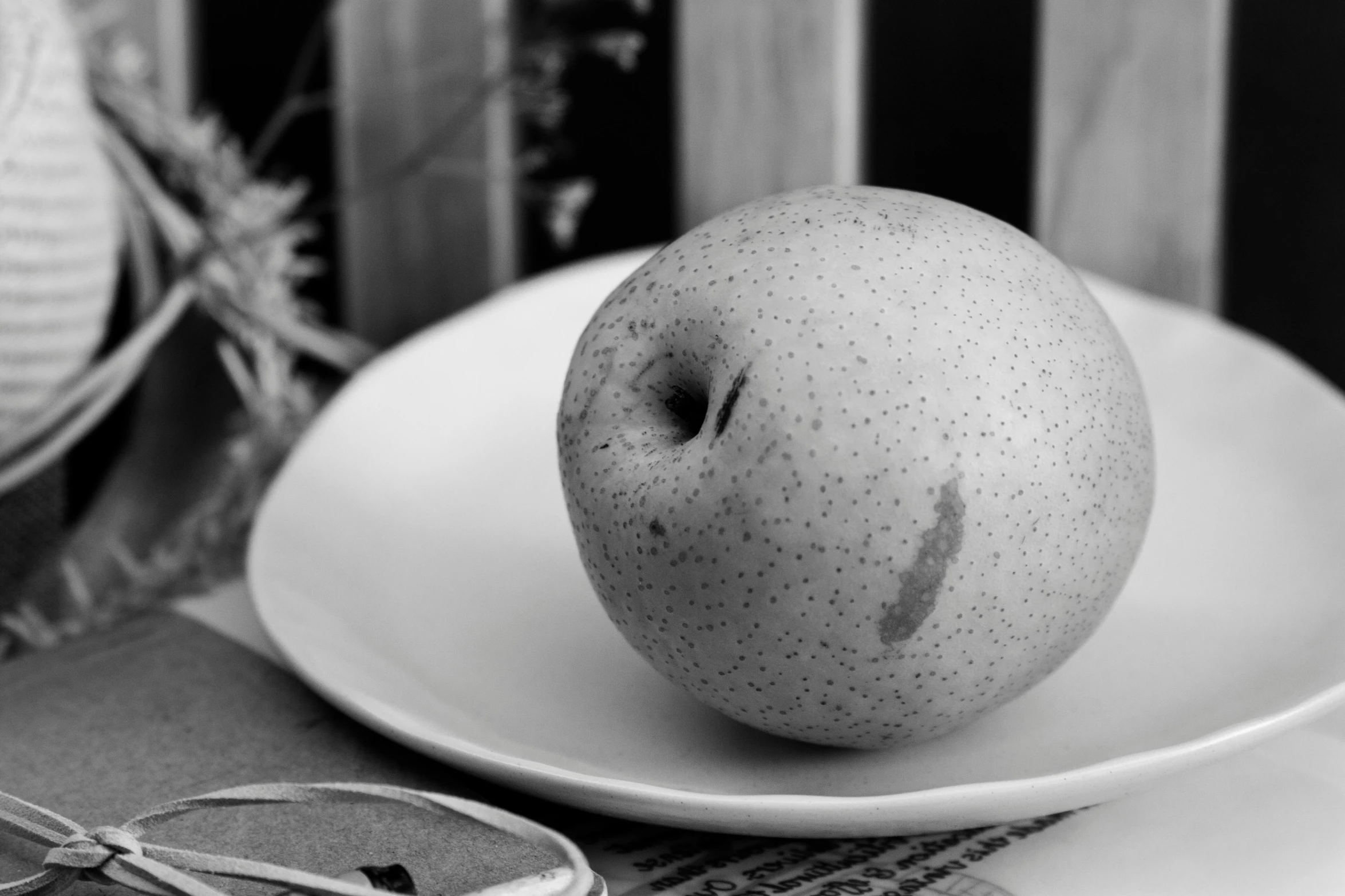 an apple and pair of scissors are sitting on the table