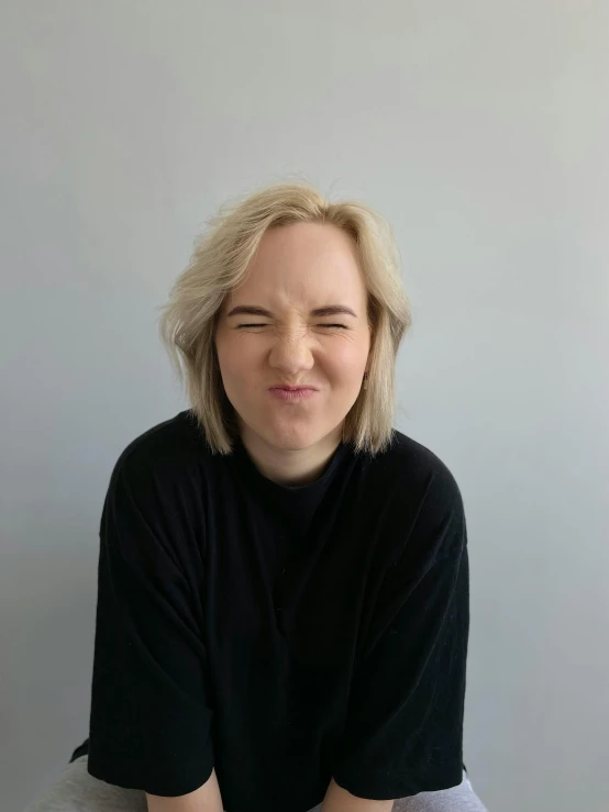 a woman with blonde hair wearing a black top