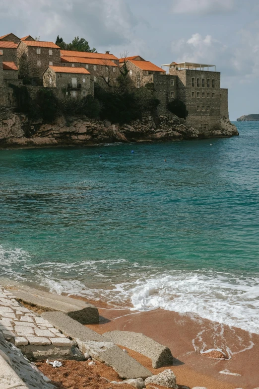 a group of buildings overlooking water next to a shore