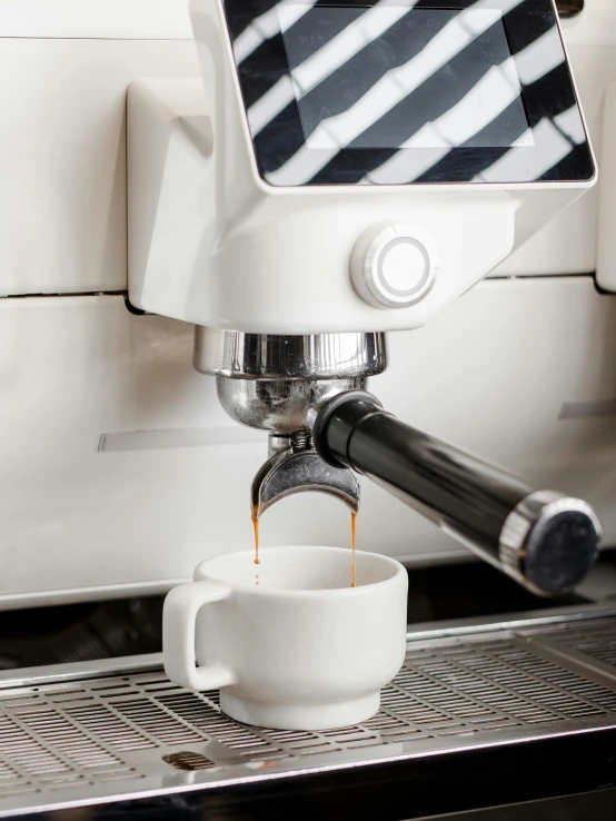 a coffee machine pouring coffee from a cup