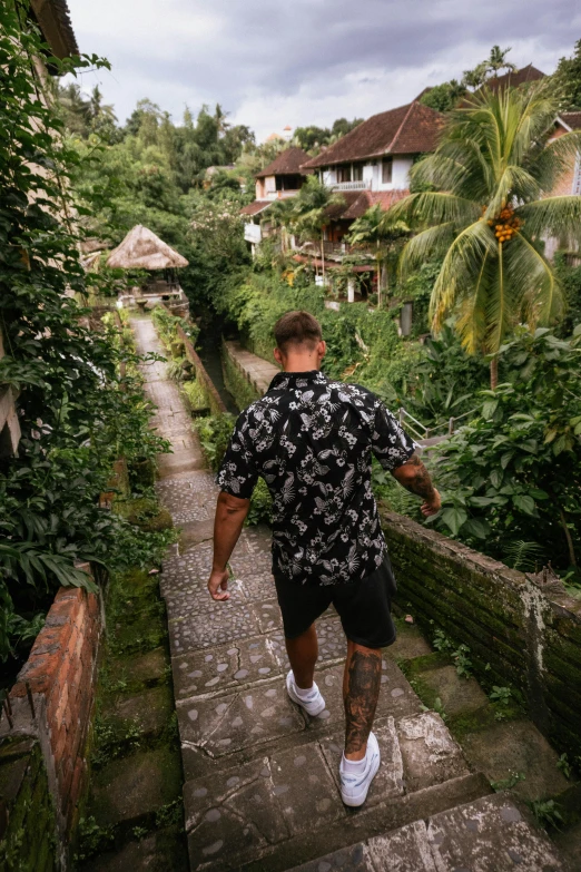 man walking up a flight of stairs in the jungle