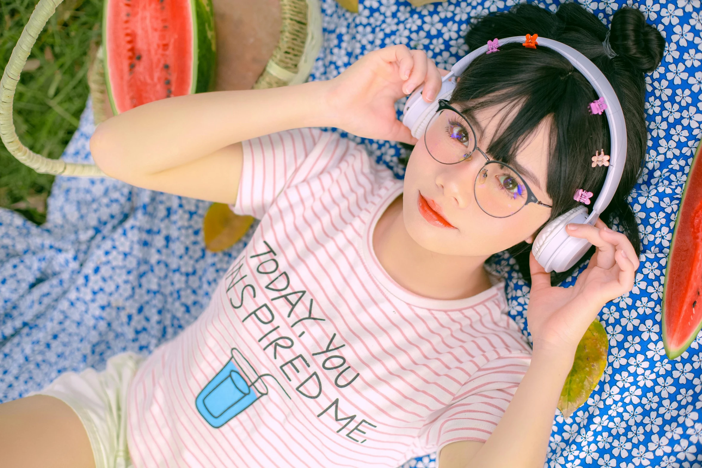 a girl laying on top of watermelon slices with headphones