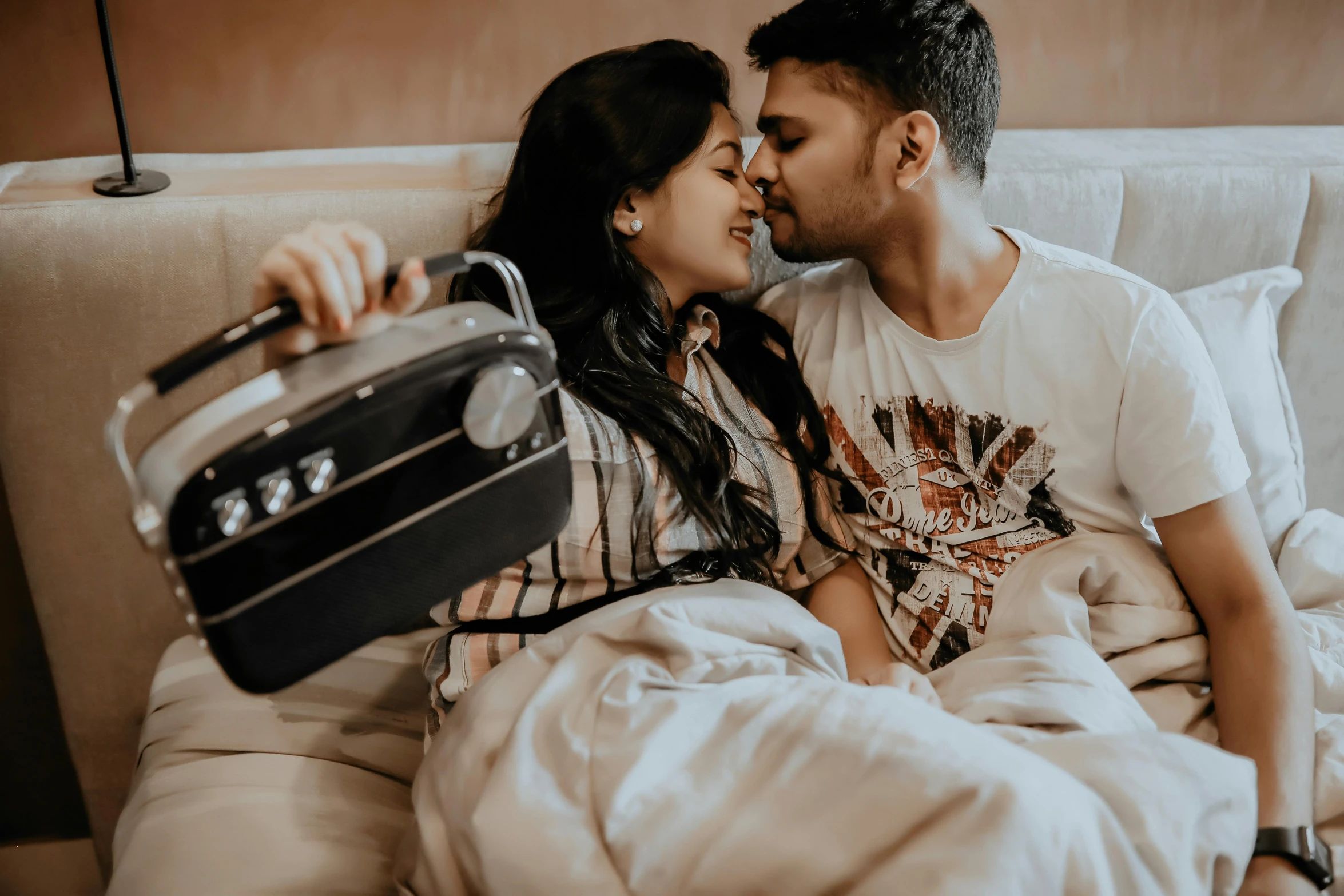 an attractive woman kissing the forehead of a man