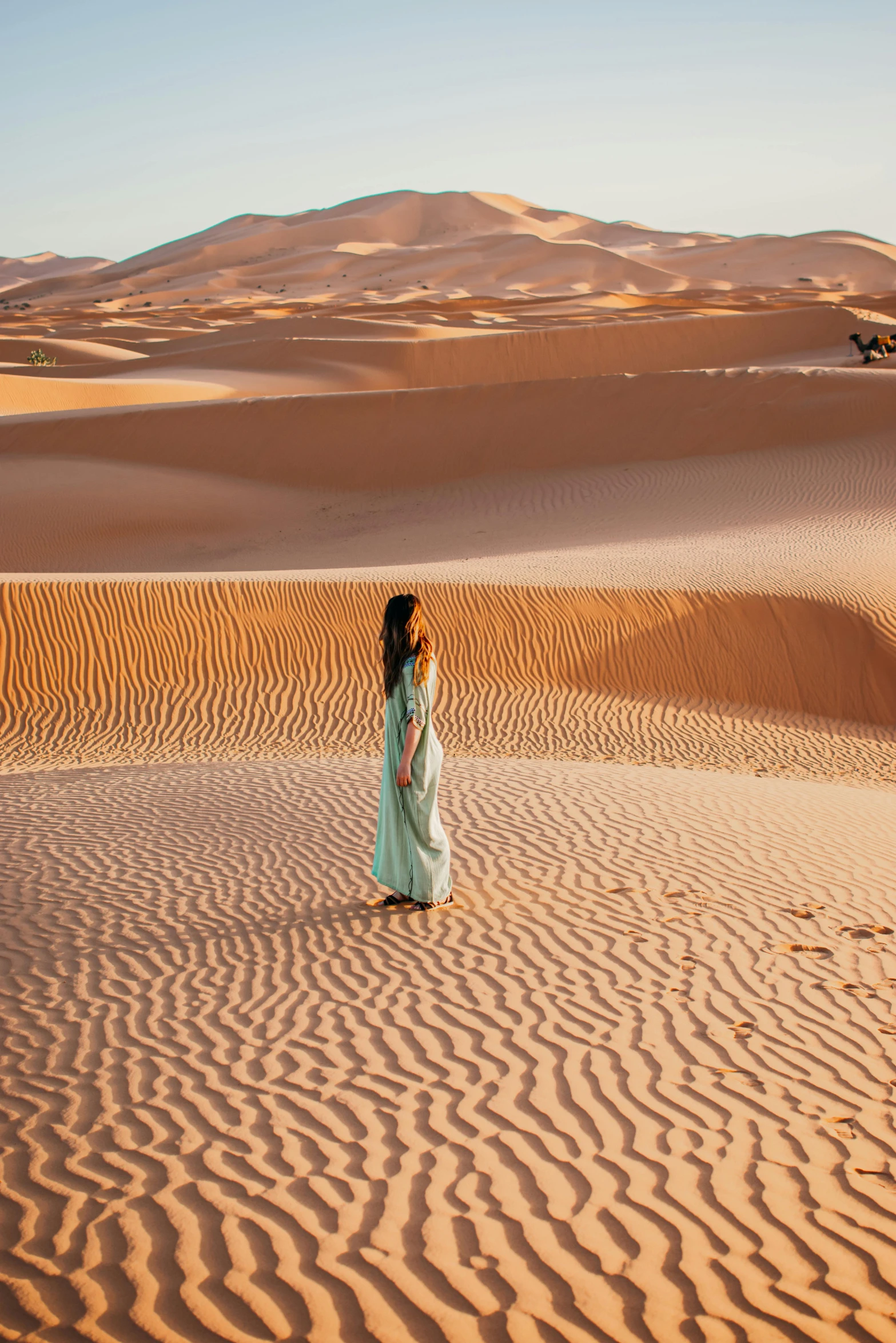 a woman standing in the middle of a desert with the dune dunes