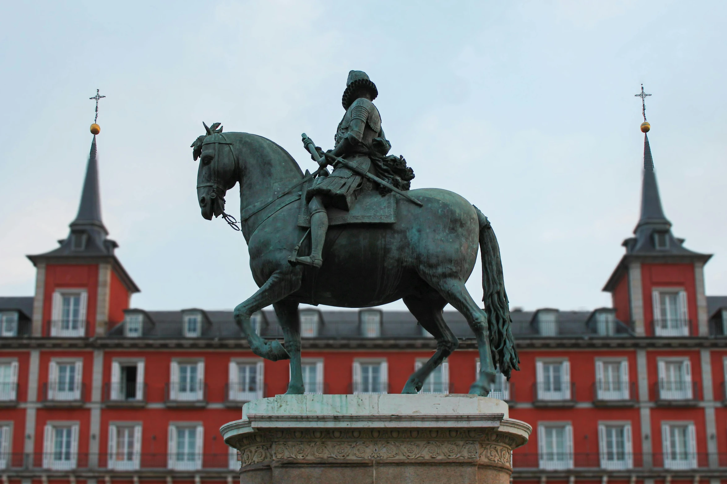 a large brick building with some people riding on horseback