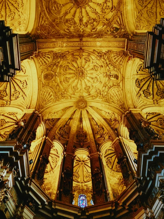 the ceiling in a cathedral is ornately adorned with intricate tiles