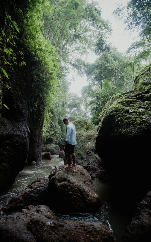 a man standing on top of a rocky river