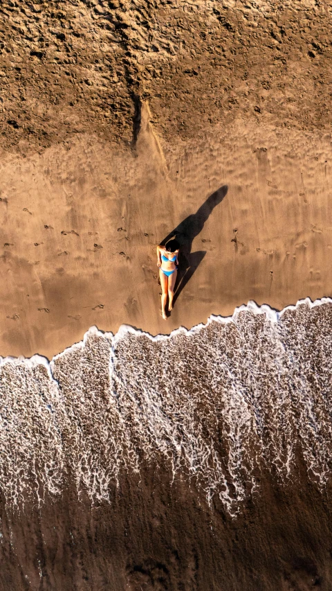 a man standing on top of a sandy beach