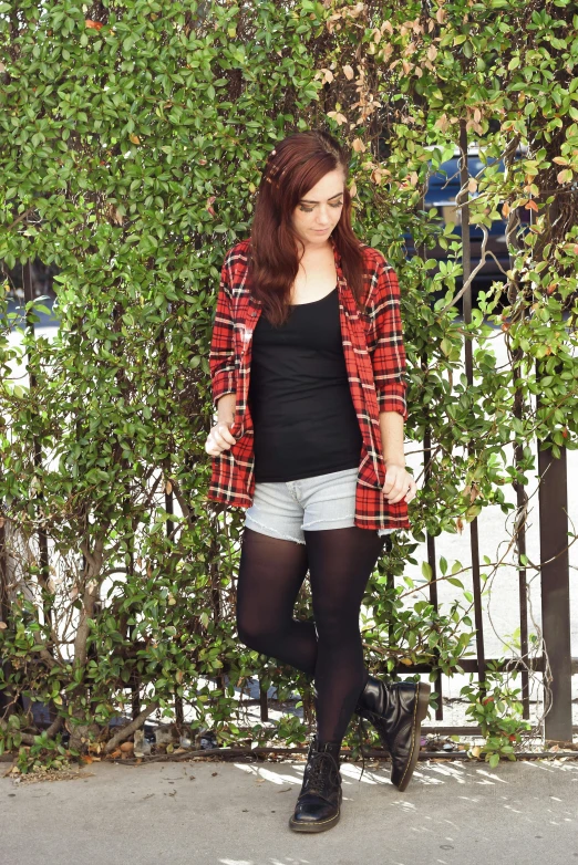 a young woman poses with her arm over her knees