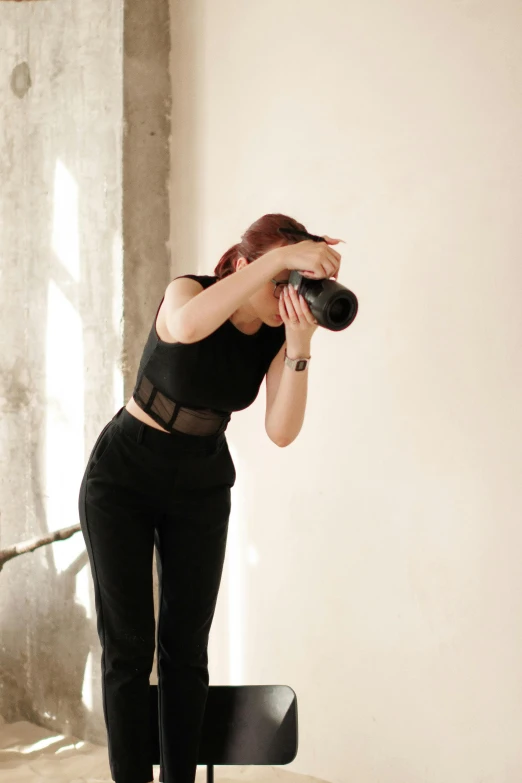 a woman is standing on a small chair, taking a po