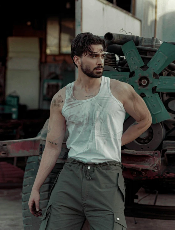 a man standing next to a machine and a green truck