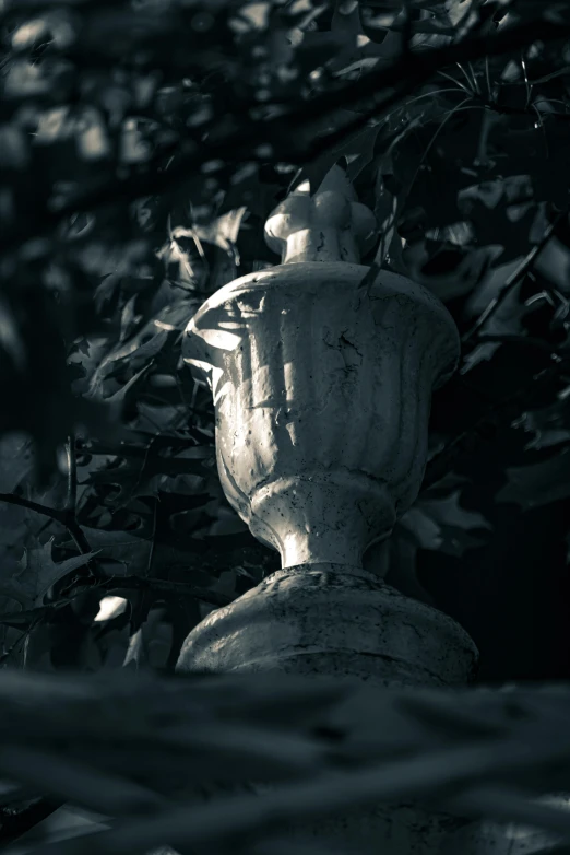 there is a stone water fountain that is next to a leafy tree