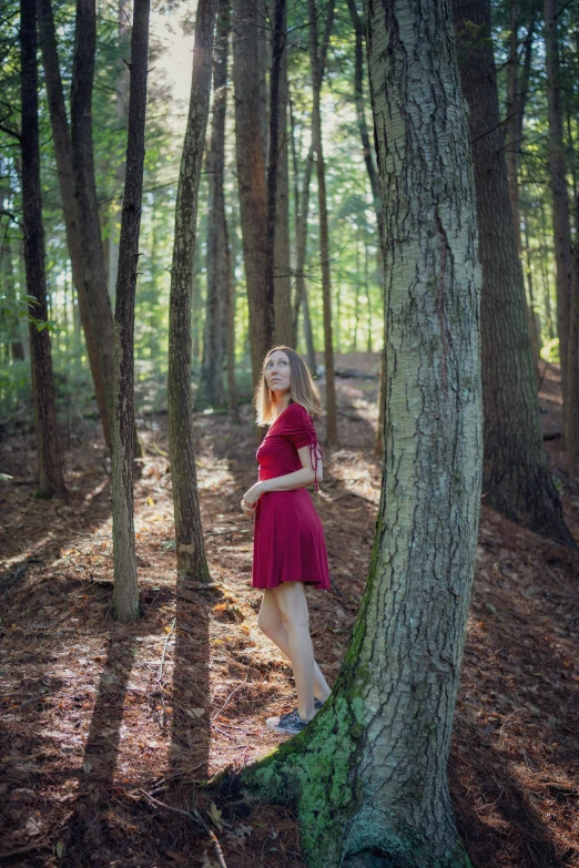 a woman in red dress near a tree