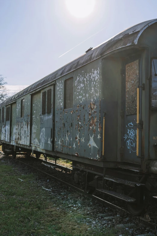 old train car sitting abandoned on the side of the train tracks