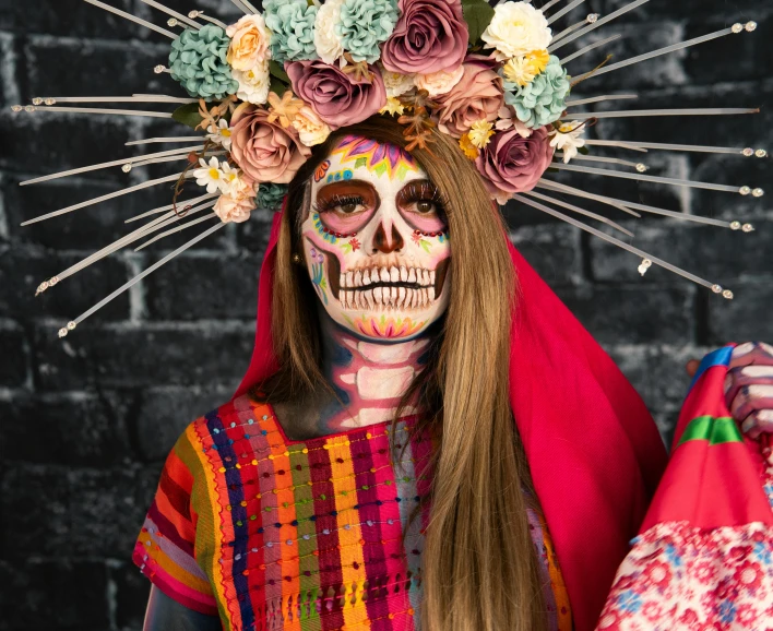 a woman with day of the dead makeup in red and gold