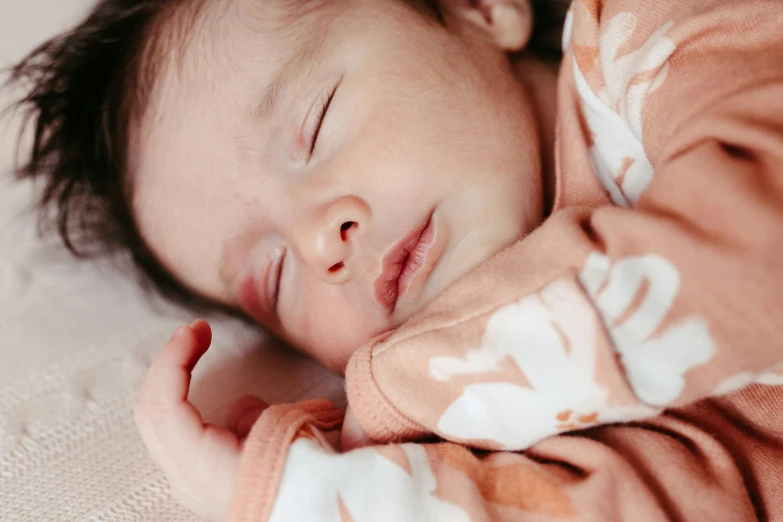 a close up of a newborn baby laying on a bed