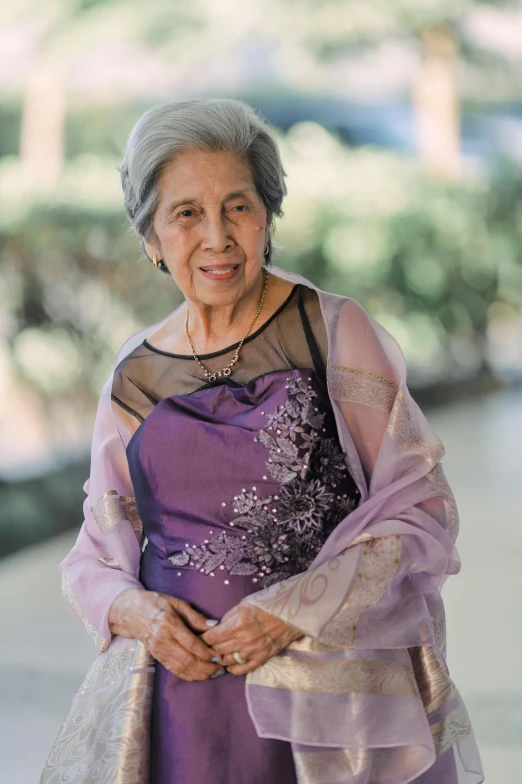 an old woman in an oriental dress poses for a po