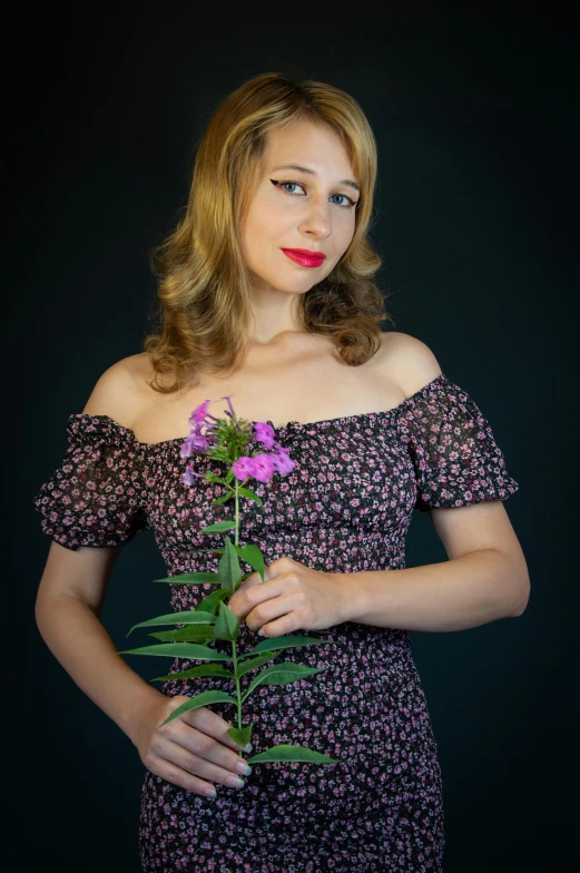 a woman with long hair holding a flower