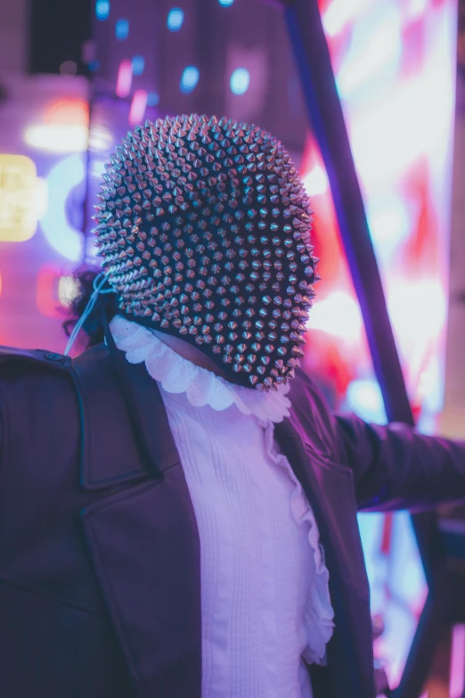 a person wearing a weird hat next to a stage