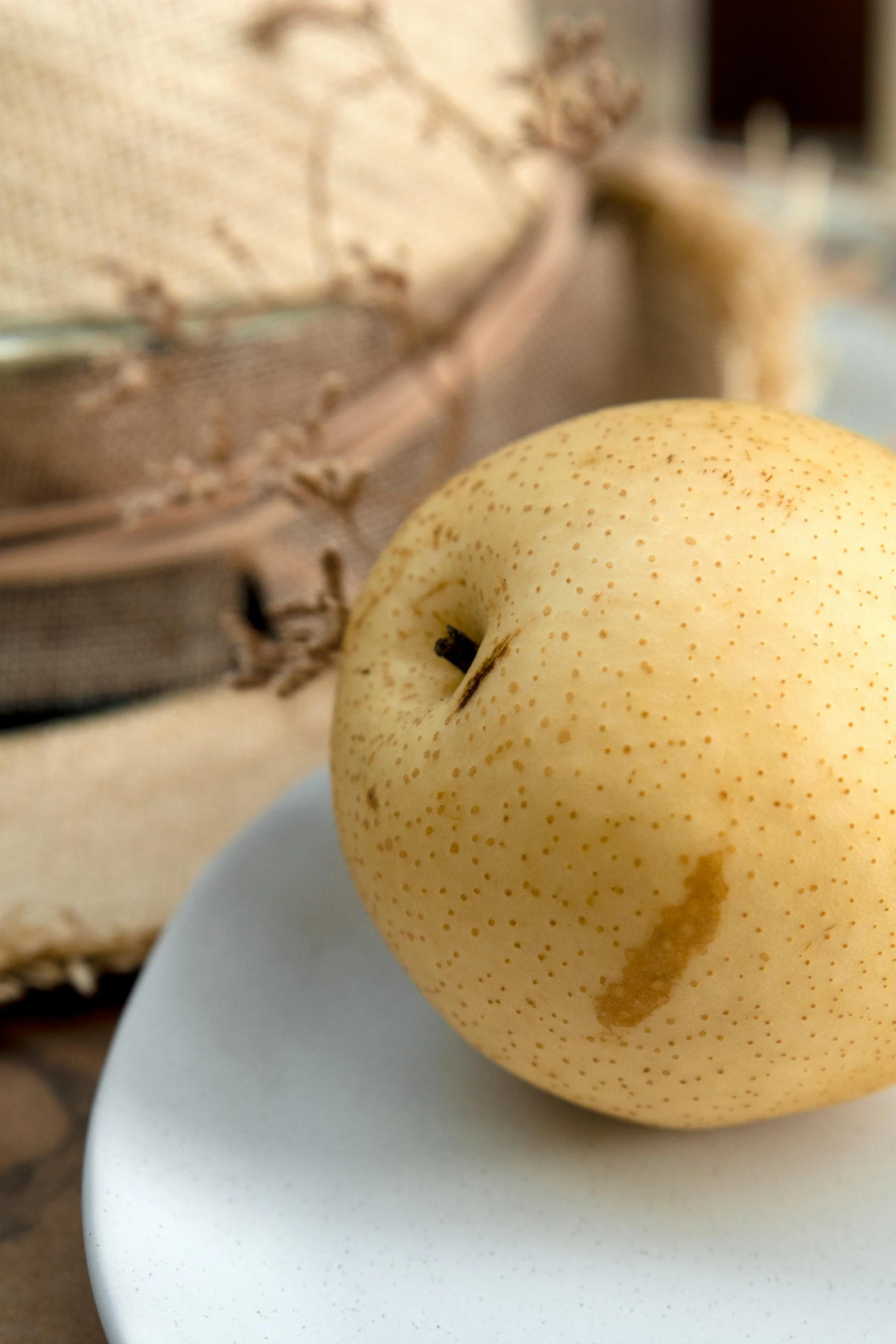 the yellow apple is on the white plate