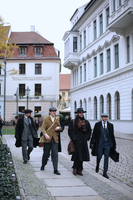 a bunch of men are on the street, some wearing coats and hats