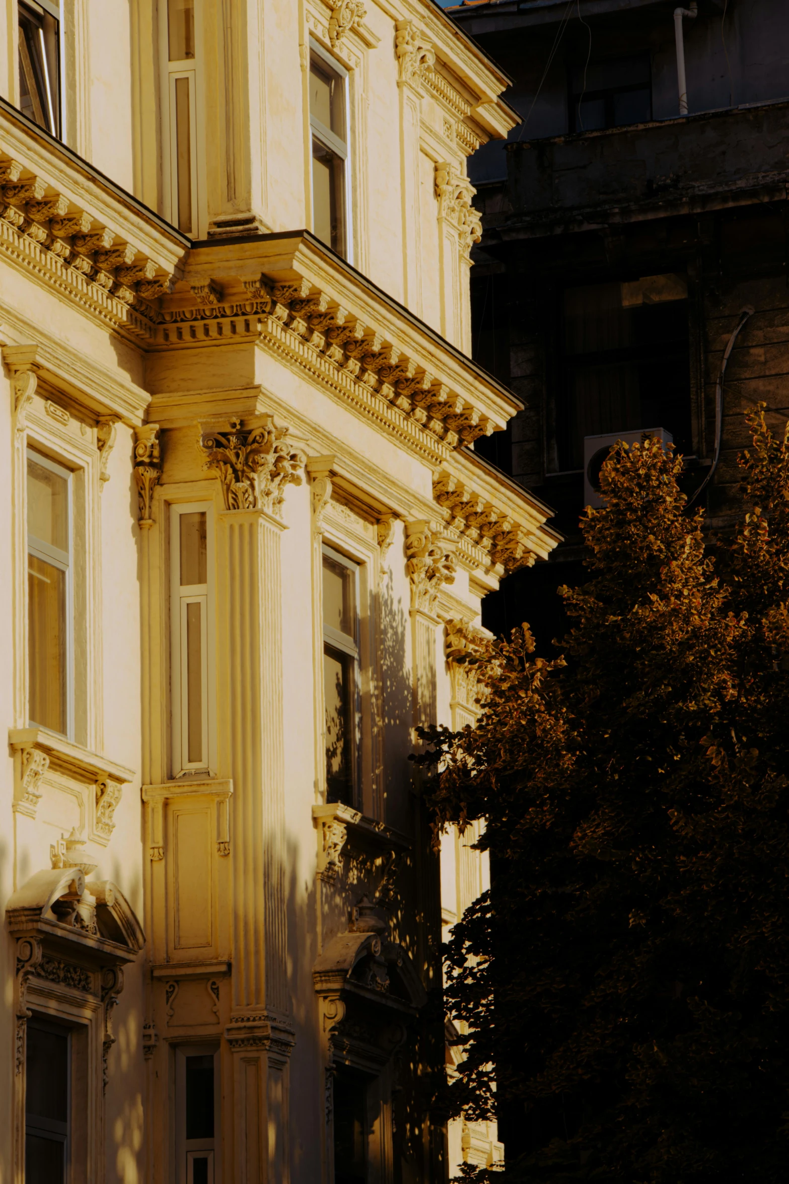 a white building with columns on it next to trees