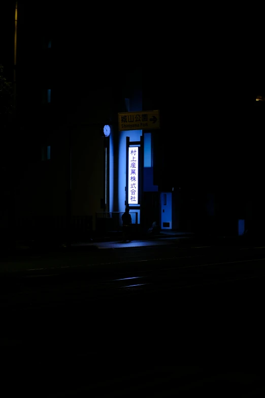 an intersection in the dark is lit by streetlights