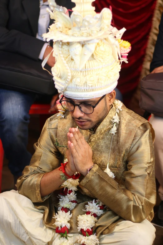 a man in a wedding suit has a flower on his head